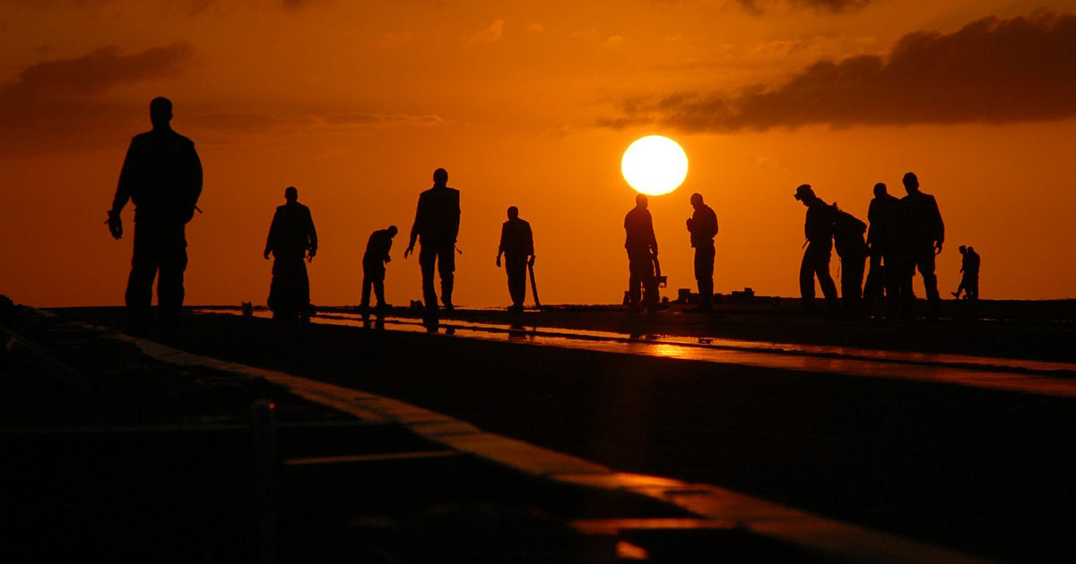 Workers in the field at sunset