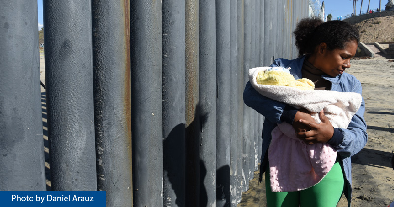 An asylum seeker walks along the border