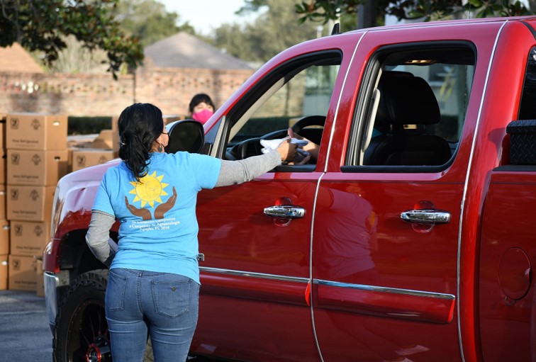 A volunteer talks to a person in their car