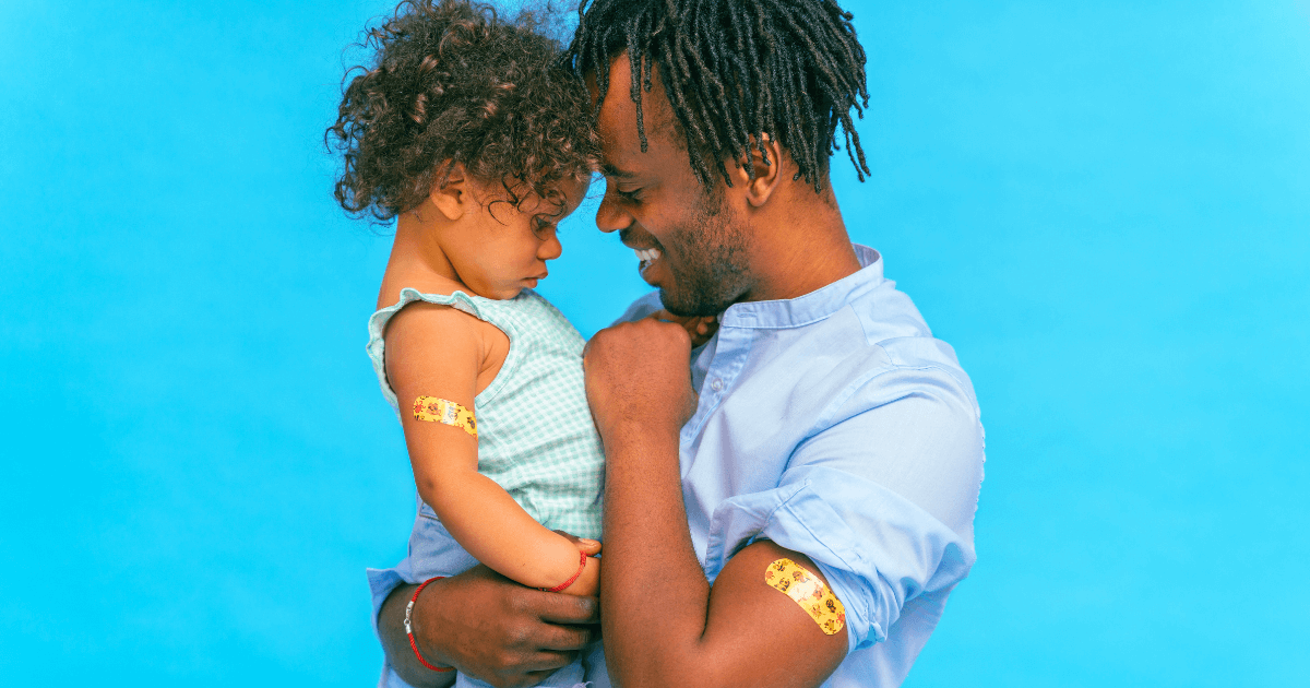 A father and child with band-aids from receiving a vaccine