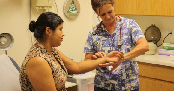 A clinician checks someone's blood pressure