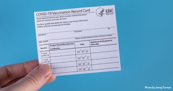 A person holding a vaccination record card