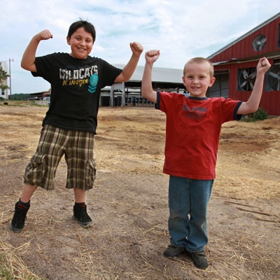 Two kids posing for a photo on a farm