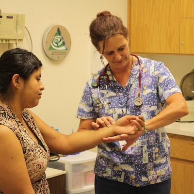 A clinician checks patient's blood pressure