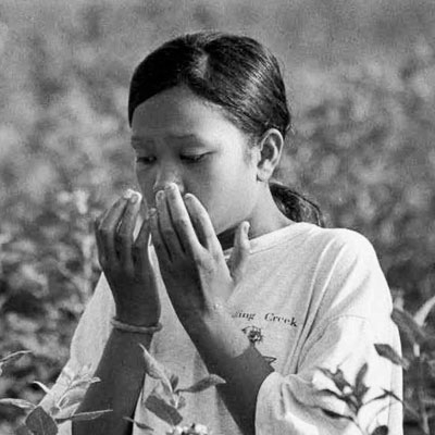 young woman worker in field holding her hands to her face