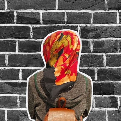 woman in hijab from behind facing brick wall with united states map