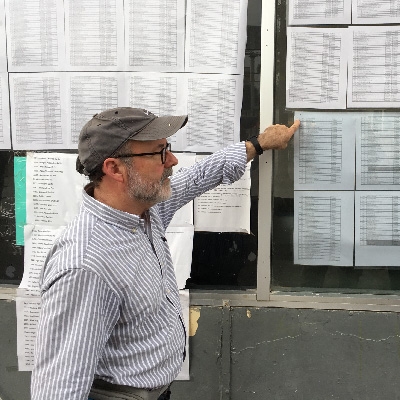 Mike Seifert looks at list of names of immigrants waiting to cross the border.