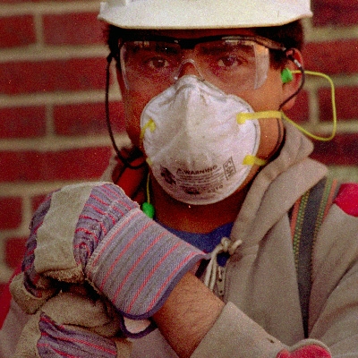 A worker wearing a mask and protective gear